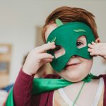 boy holding green mask