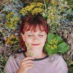 woman in gray crew neck shirt lying on green grass