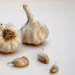 garlic bulb and garlic on white surface