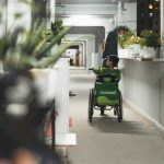 a person pushing a child in a stroller down a hallway
