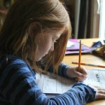 Girl Drawing On Brown Wooden Table