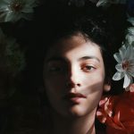 Selective Focus Photography of Woman Lying on Flowers