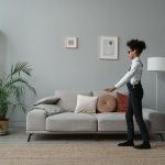 A Child Wearing Sunglasses Walking on a Rug Beside a Sofa