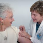 woman inject a woman on left shoulder