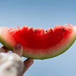 person holding sliced watermelon