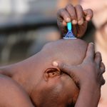 man shaving his head